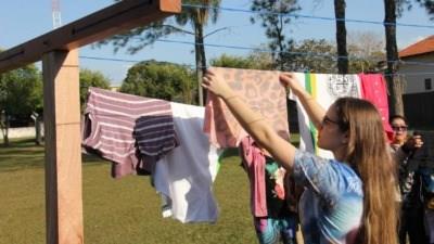 Jovens organizam as roupas para o varal solidário